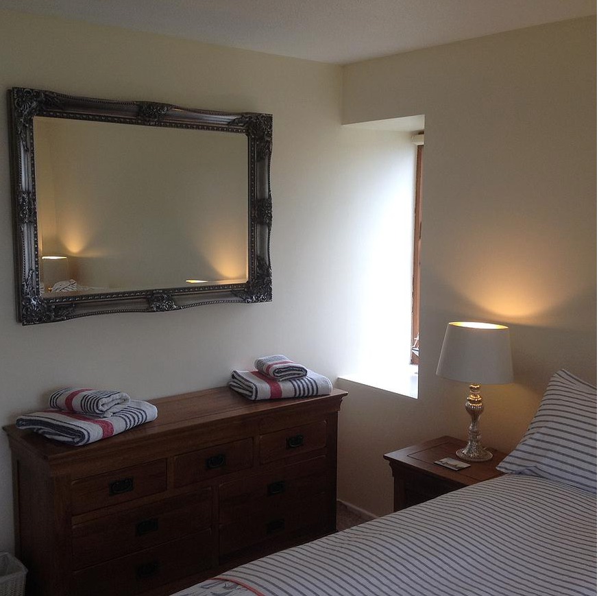Beautiful mirror and large chest of drawers in main bedroom.